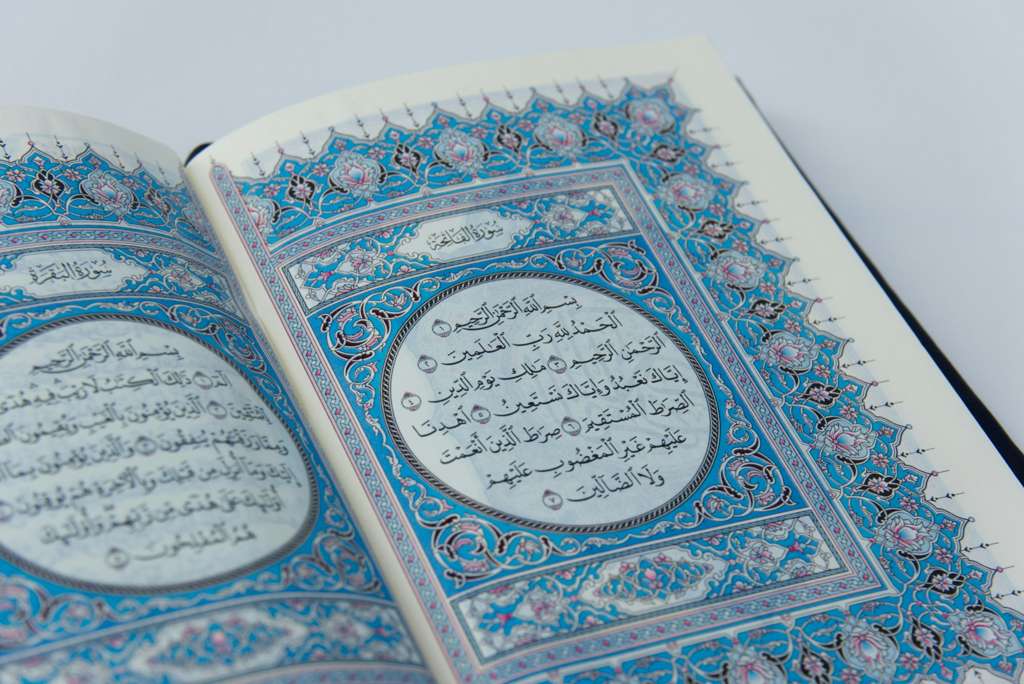 An open Holy Quran with ornate calligraphy